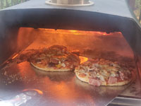 Slide it into the wood burning oven.